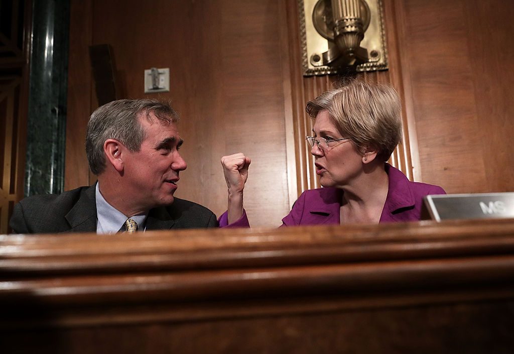 WASHINGTON, DC - APRIL 07: U.S. Sen. Jeff Merkley (D-OR) (L) talks to Sen. Elizabeth Warren (D-MA) (R) prior to a hearing before the Senate Banking, Housing and Urban Affairs Committee April 7, 2016 on Capitol Hill in Washington, DC. The committee held a hearing on "The Consumer Financial Protection Bureau's Semi-Annual Report to Congress." (Photo by Alex Wong/Getty Images)