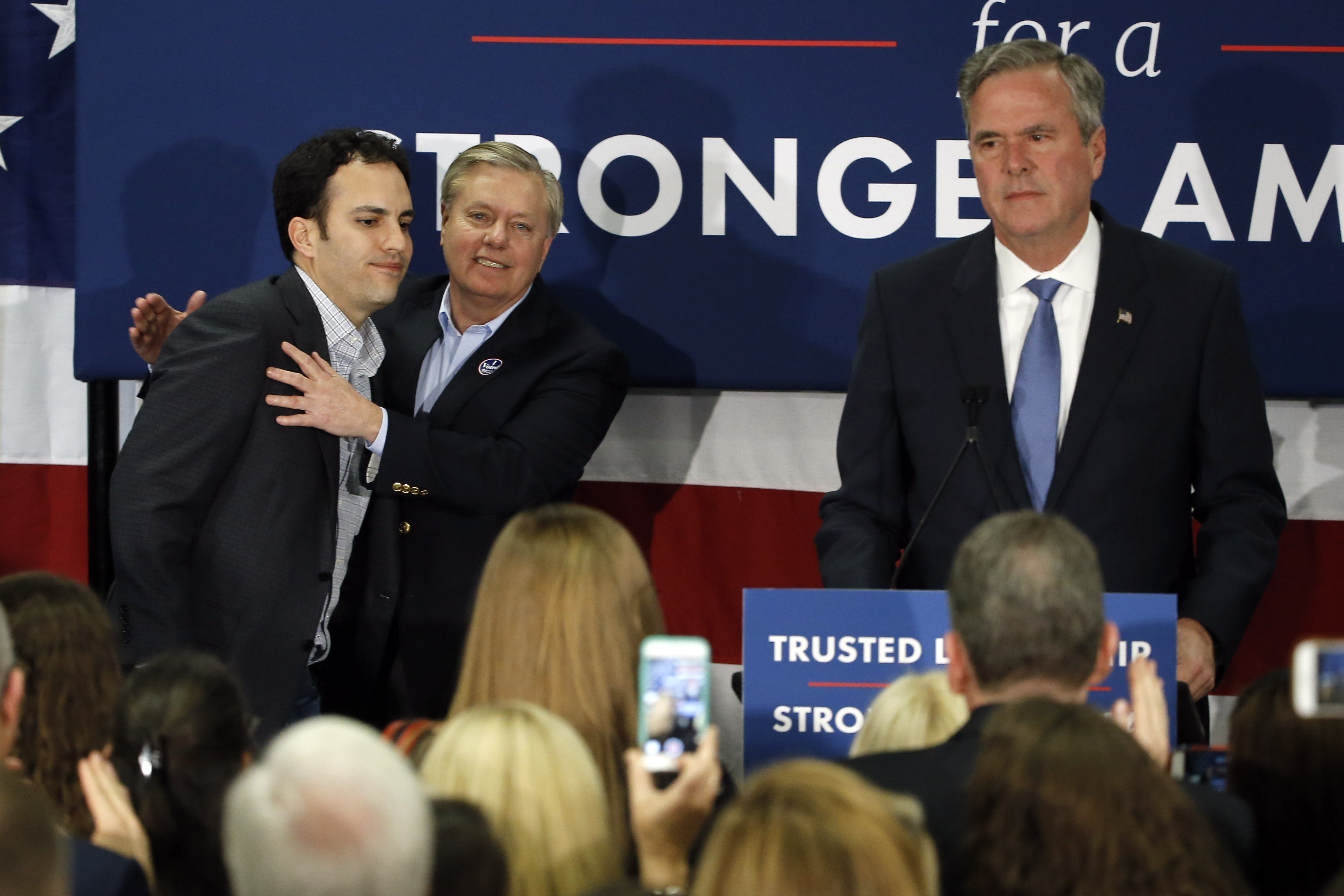 Republican presidential candidate, former Florida Gov. Jeb Bush, right, is accompanied by his son, Jeb Bush Jr., left, and Sen. Lindsey Graham, R-S.C., as he speaks at his South Carolina Republican presidential primary rally in Columbia, S.C., Saturday, Feb. 20, 2016. (AP Photo/Matt Rourke)