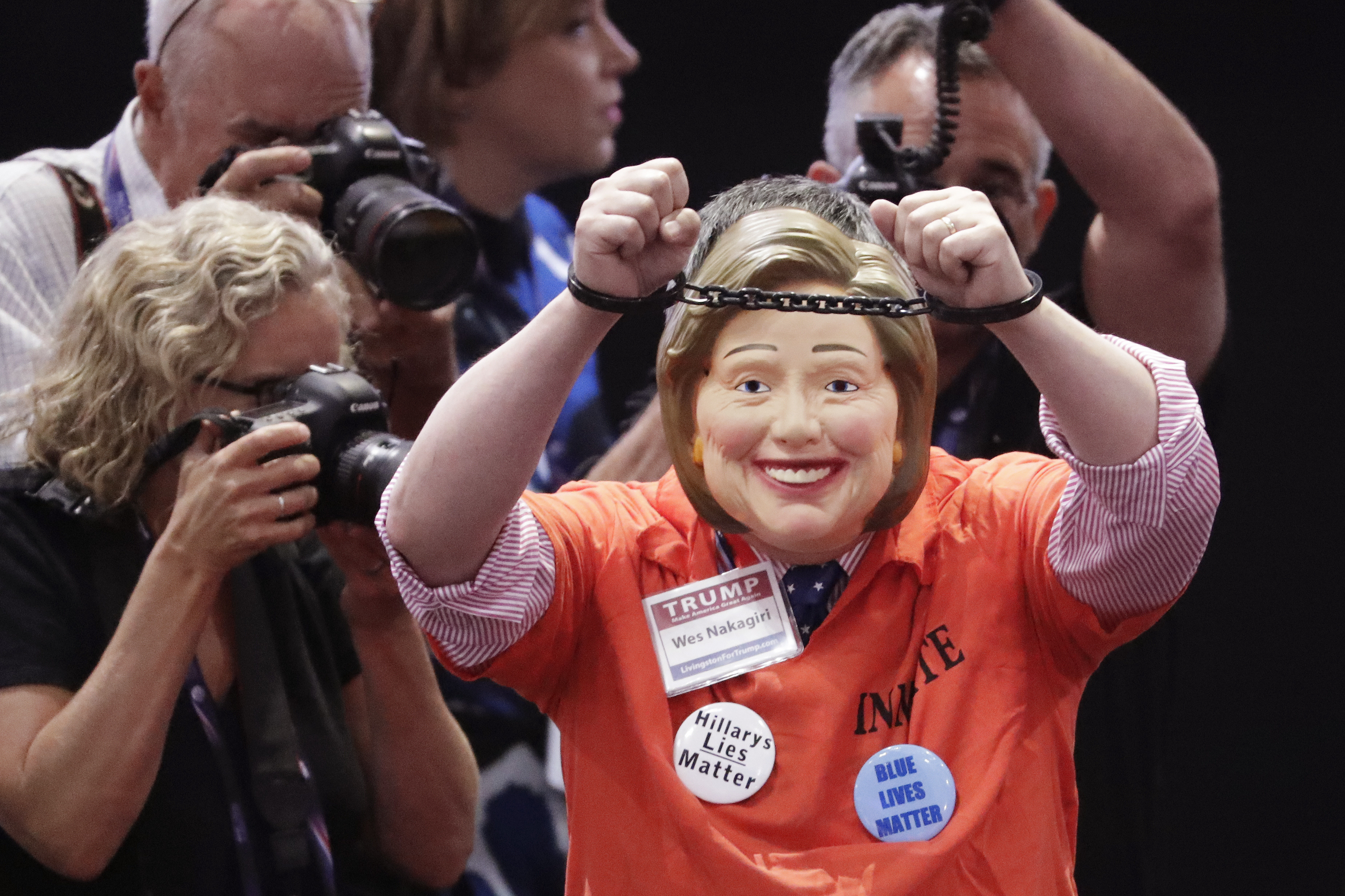 Una mujer disfrazada de Hillary Clinton simula estar esposada./AP